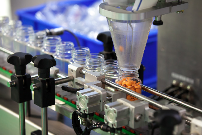Pills being bottled at a pharmaceutical production facility